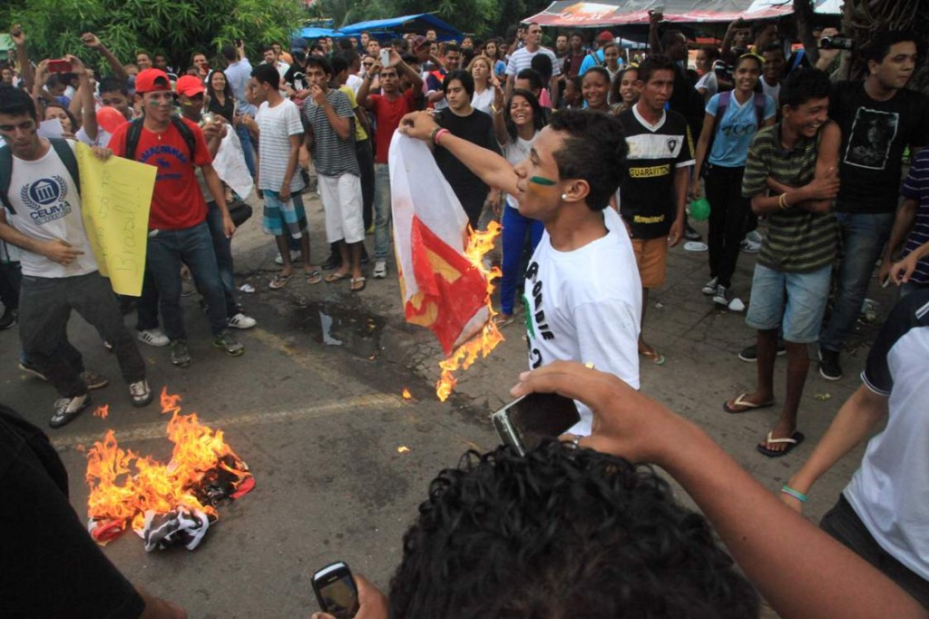 Manifestante segura bandeira do PSTU queimada em São Luís (Foto: De Jesus/O Estado)
